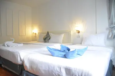 two beds in a hotel room with blue pillows at Chilli Salza Patong in Patong Beach