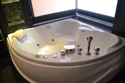 a white bath tub in a bathroom with a window at Absolute bangla suites 65 sqm with Jacuzzi in Patong Beach