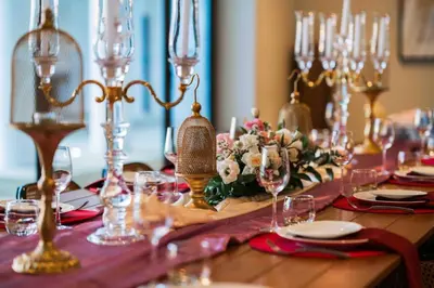 a table with a table set with glasses and flowers at \u9759\u6e7e\u4e4b\u8679VILLA SHOOWA Cape Yamu\u5962\u534e\u6d77\u666f\u522b\u5885 in Ban Bang La