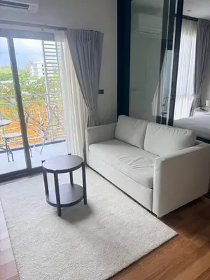 a living room with a white couch and a table at Halo 1 Title Naiyang beach in Phuket Town