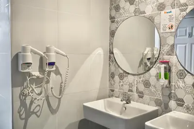 a bathroom with a sink and a mirror at Friends Hostel - Phuket Airport in Nai Yang Beach