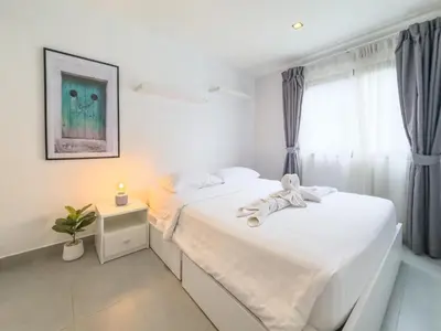 a bedroom with a white bed and a window at Garden View Apartment 1BR - NV-103 in Chalong
