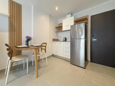 a kitchen with a table and a stainless steel refrigerator at Garden View Apartment 1BR - NV-103 in Chalong