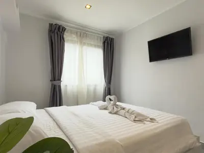 a bed with a ribbon on it with a window at Garden View Apartment 1BR - NV-103 in Chalong