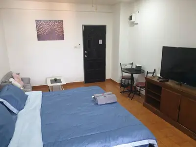 a bedroom with a bed and a flat screen tv at Monkey Apartment in Patong Beach