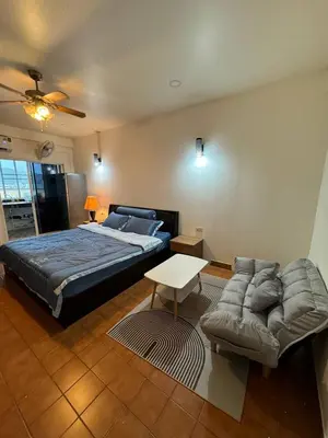 a bedroom with a king sized bed and a couch at Monkey Apartment in Patong Beach