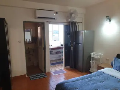 a room with a refrigerator and a bedroom with a bed at Monkey Apartment in Patong Beach