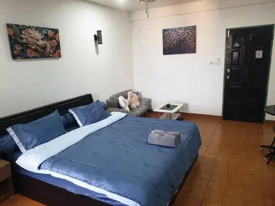 a bedroom with a large bed with a blue blanket at Monkey Apartment in Patong Beach