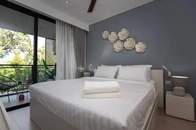 a bedroom with a large bed with white sheets at Cassia 1BR City View apt by NLA in Bang Tao Beach