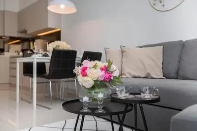 a living room with a couch and a table with a vase of flowers at Cassia 1BR City View apt by NLA in Bang Tao Beach