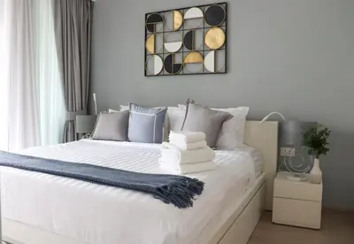 a bedroom with a white bed with blue pillows at Cassia 1BR City View apt by NLA in Bang Tao Beach