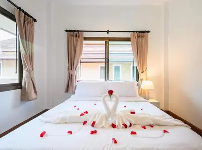 a white bed with roses and a swan on it at Pool Villa Tambon Patong in Patong Beach