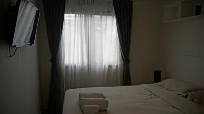 a bedroom with a bed and a window with a television at Island Escape 1BR T1-206 in Chalong