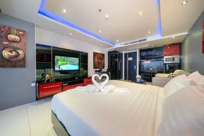 a bedroom with a white bed with a towel on it at Studio Apartment in Bangla Rd in Patong Beach