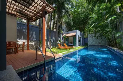 a swimming pool with a patio and a house at Saiyuan Estate by TropicLook in Rawai Beach