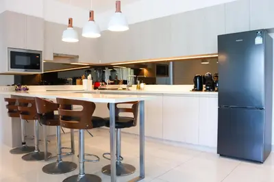 a kitchen with a table and chairs and a refrigerator at Cassia 3BR Sea View apt by NLA in Bang Tao Beach