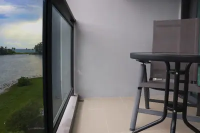 a stool sitting on a balcony with a view of the water at Cassia 3BR Sea View apt by NLA in Bang Tao Beach
