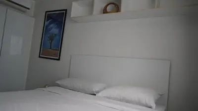 a bedroom with a white bed and a picture on the wall at Bright & Breezy -1BR T1-211 in Chalong