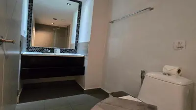 a bathroom with a toilet and a sink and a mirror at Bright & Breezy -1BR T1-211 in Chalong
