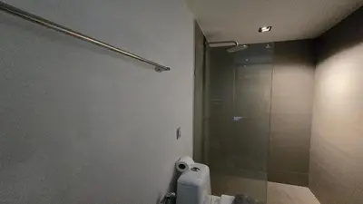 a bathroom with a shower and a toilet paper dispenser at Bright & Breezy -1BR T1-211 in Chalong