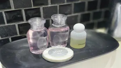two glass bottles and a soap container on a shelf at Bright & Breezy -1BR T1-211 in Chalong