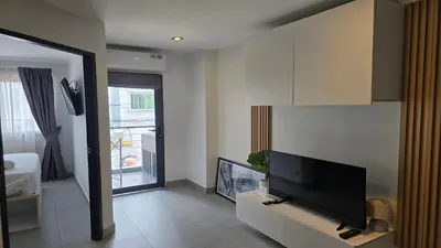 a living room with a flat screen tv on a wall at Bright & Breezy -1BR T1-211 in Chalong