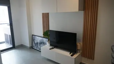 a living room with a flat screen tv on a cabinet at Bright & Breezy -1BR T1-211 in Chalong