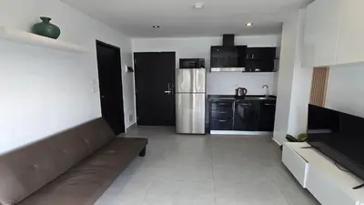 a living room with a couch and a kitchen at Big Buddha View Apt-1BR T1-306 in Chalong