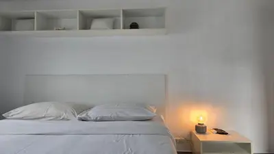 a bed with a white headboard and a table with a light at Big Buddha View Apt-1BR T1-306 in Chalong