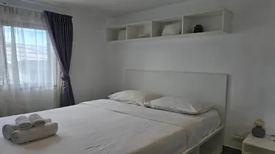 a bedroom with a bed with white sheets and a window at Big Buddha View Apt-1BR T1-306 in Chalong