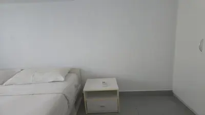 a white bedroom with a bed and a night stand at Boutique Comfort 1BR T2-410 in Chalong