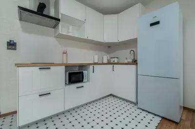 a white kitchen with white cabinets and a microwave at Two Flamingo Apartment 1 in Nai Yang Beach