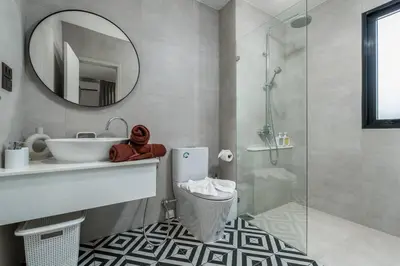 a bathroom with a sink and a toilet and a mirror at Two Flamingo Apartment 1 in Nai Yang Beach