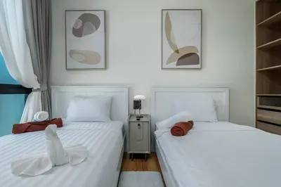 two beds sitting next to each other in a bedroom at Two Flamingo Apartment 1 in Nai Yang Beach