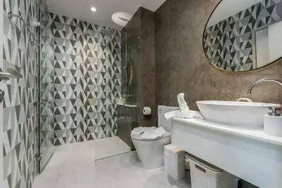 a bathroom with a sink and a toilet and a mirror at Two Flamingo Apartment 1 in Nai Yang Beach