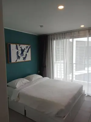 a bedroom with a large white bed and a window at Modern & Cozy Apartment 1BR - NV-413 in Chalong