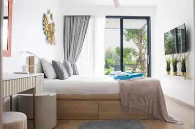 a bedroom with a large bed with a window at Cassia 3BR with Terrace Sea view apt by NLA in Phuket Town