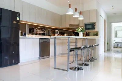 a kitchen with a bar with stools in it at Cassia 3BR with Terrace Sea view apt by NLA in Phuket Town