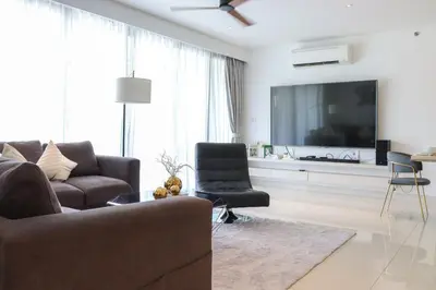 a living room with a couch and a flat screen tv at Cassia 3BR with Terrace Sea view apt by NLA in Phuket Town