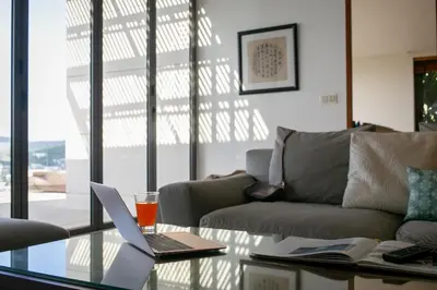 a living room with a laptop on a glass table at Panoramic Sea View Luxury Apartment - Leelawadee21 in Kata Beach