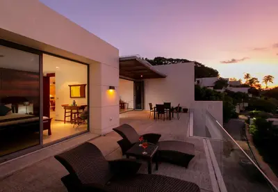 a balcony of a house with chairs and a table at Panoramic Sea View Luxury Apartment - Leelawadee21 in Kata Beach
