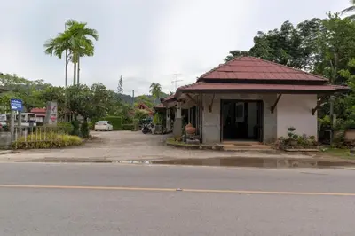 a small building with a red roof next to a street at OYO 1046 Noppharat resort in Ao Nang Beach