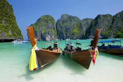two boats in the water in front of a beach at OYO 1046 Noppharat resort in Ao Nang Beach