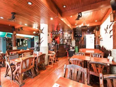 a restaurant with wooden tables and wooden chairs at OYO 1103 Pirates House Hotel in Phi Phi Don