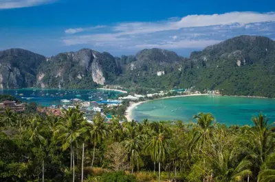 a view of a beach with palm trees and mountains at OYO 1103 Pirates House Hotel in Phi Phi Don