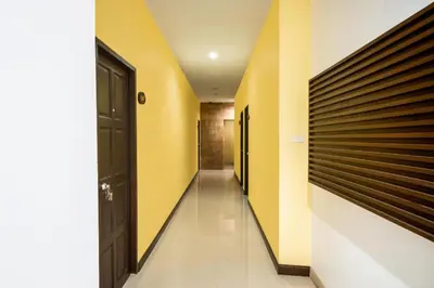 a hallway with yellow and white walls and a door at OYO 232 Patong City Hometel in Patong Beach