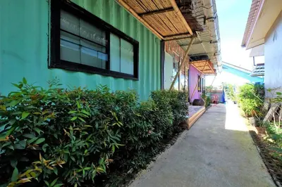 a green building with a window on the side of it at OYO 503 Phuket Numnoi in Surin Beach