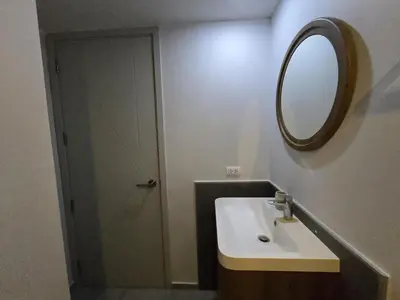 a bathroom with a sink and a mirror and a door at Cozy & Modern -1BR - T2 416 in Phuket Town
