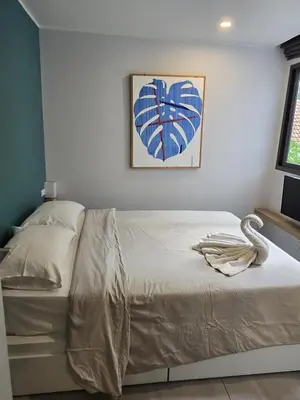 a bed in a bedroom with a painting on the wall at Cozy & Modern -1BR - T2 416 in Phuket Town