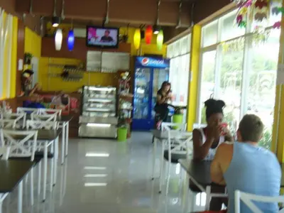 a group of people sitting at tables in a restaurant at My Place Phuket Airport Mansion in Ban Bo Han